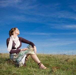 Woman wearing a skirt sitting in a field